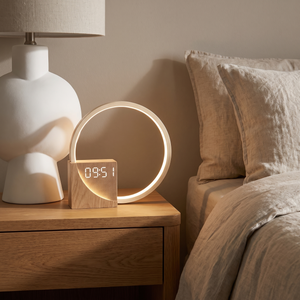 Lunara lamp lit on an oak bedside table